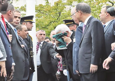 عباس يقبل علم فلسطين قبل رفعه بمقر الأمم المتحدة